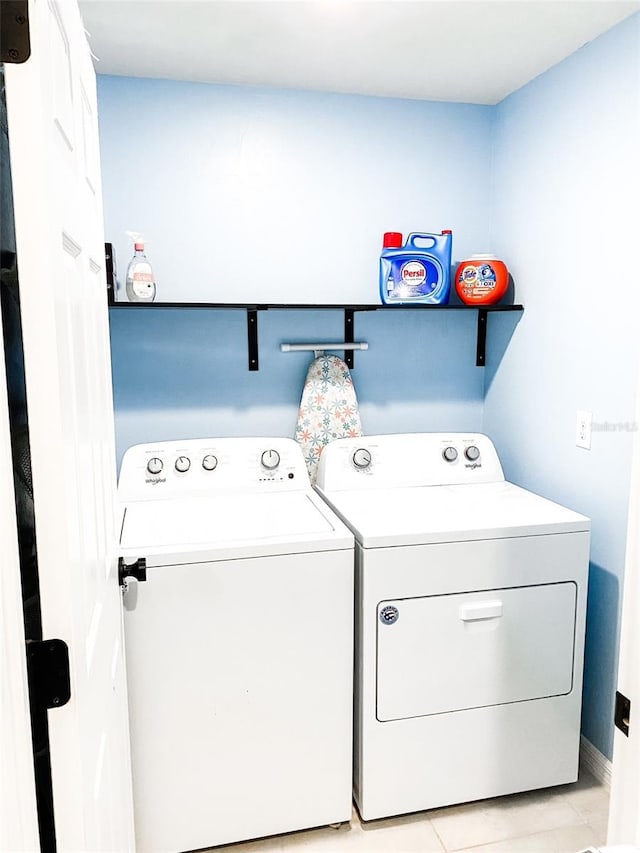 laundry room with washing machine and clothes dryer and light tile patterned floors