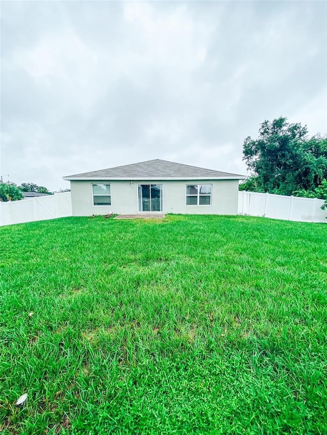 back of house with a lawn