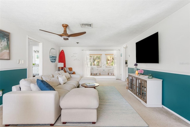 living room with french doors, ceiling fan, a textured ceiling, and light colored carpet