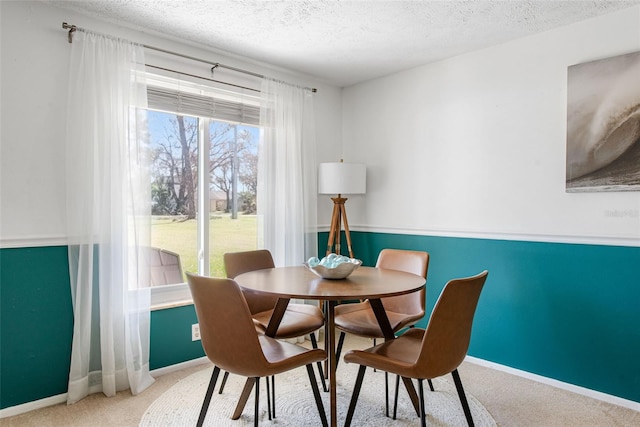 carpeted dining room featuring a textured ceiling