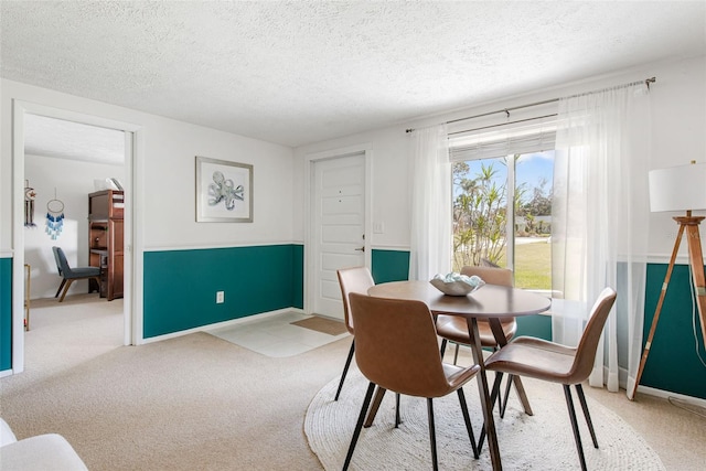 dining room with light carpet and a textured ceiling