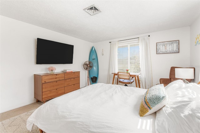 bedroom with light carpet and a textured ceiling