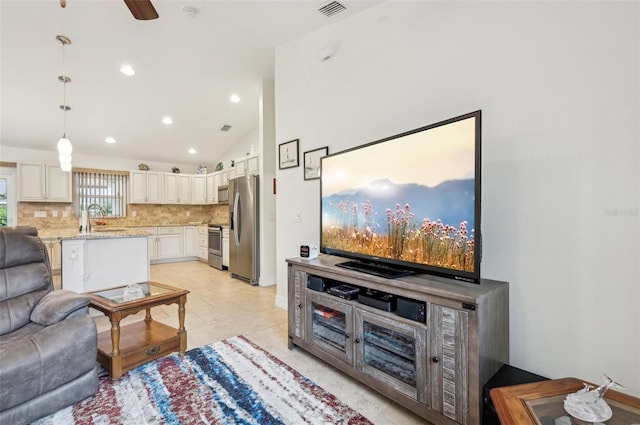 living room with ceiling fan, lofted ceiling, and sink