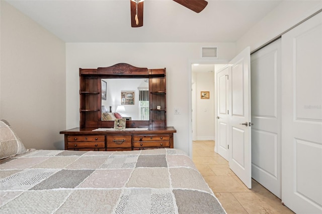 bedroom with light tile patterned floors, a closet, and ceiling fan