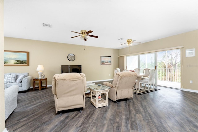 living room featuring ceiling fan and dark hardwood / wood-style flooring