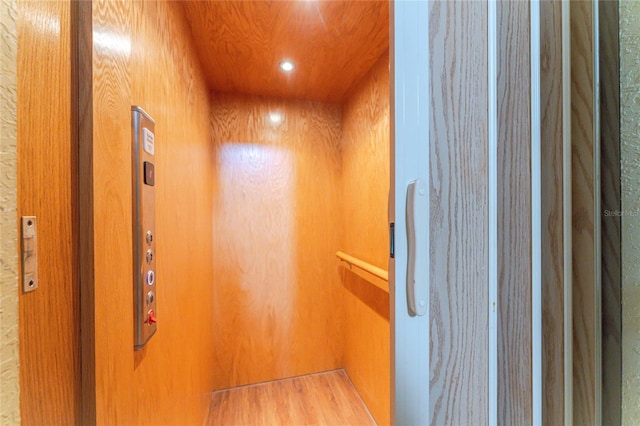 details featuring wood walls and elevator