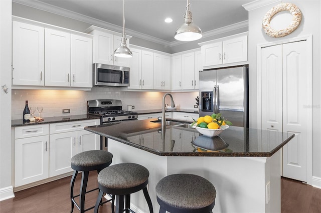 kitchen featuring pendant lighting, sink, appliances with stainless steel finishes, an island with sink, and white cabinets