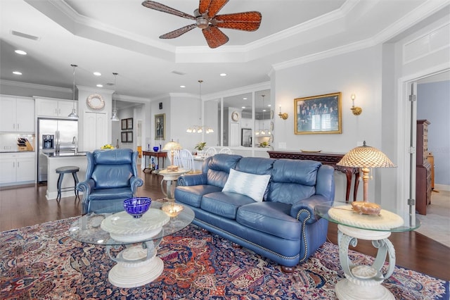 living room featuring crown molding, ceiling fan, wood-type flooring, and a raised ceiling