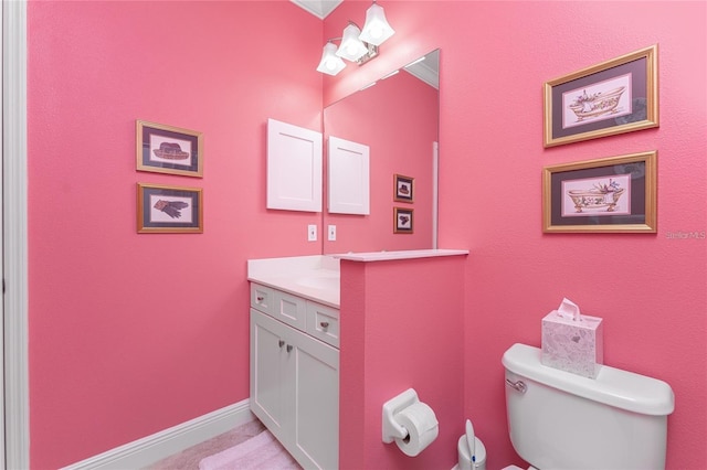 bathroom with ornamental molding, vanity, and toilet