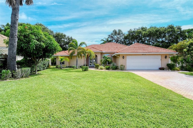 mediterranean / spanish home with a front lawn and a garage