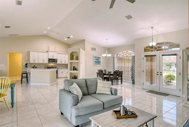 tiled living room featuring lofted ceiling and ceiling fan with notable chandelier