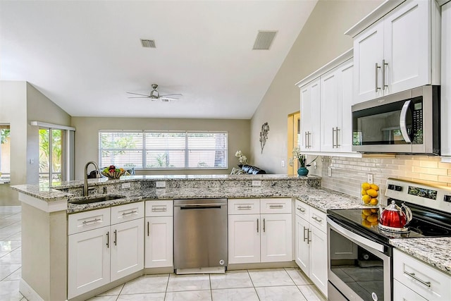 kitchen with stainless steel appliances, kitchen peninsula, lofted ceiling, and sink