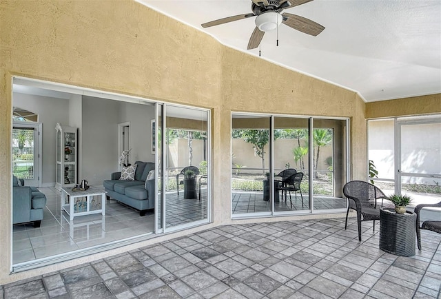 sunroom featuring lofted ceiling and ceiling fan