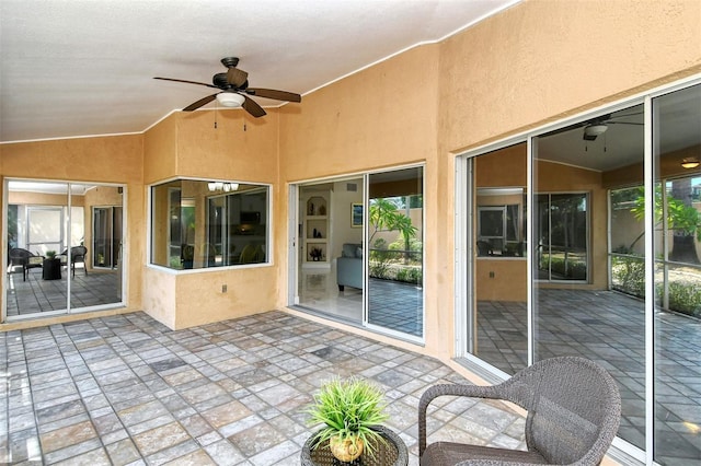 unfurnished sunroom with ceiling fan, vaulted ceiling, and a healthy amount of sunlight