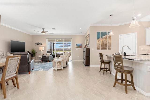 tiled living room featuring sink, crown molding, and ceiling fan