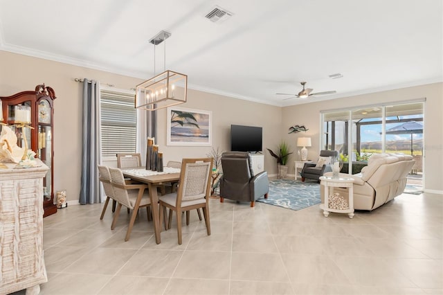 dining room featuring crown molding, light tile patterned flooring, and ceiling fan with notable chandelier