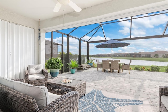 view of patio featuring a lanai, outdoor lounge area, a water view, and ceiling fan