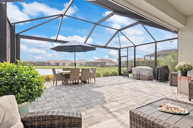 view of patio featuring a water view, a lanai, and a grill