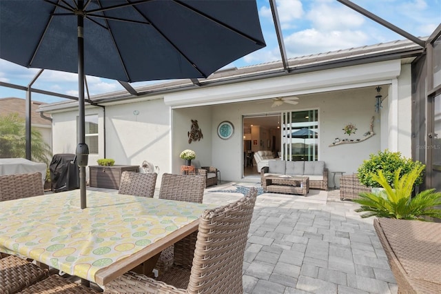 view of patio / terrace featuring outdoor lounge area, ceiling fan, and glass enclosure