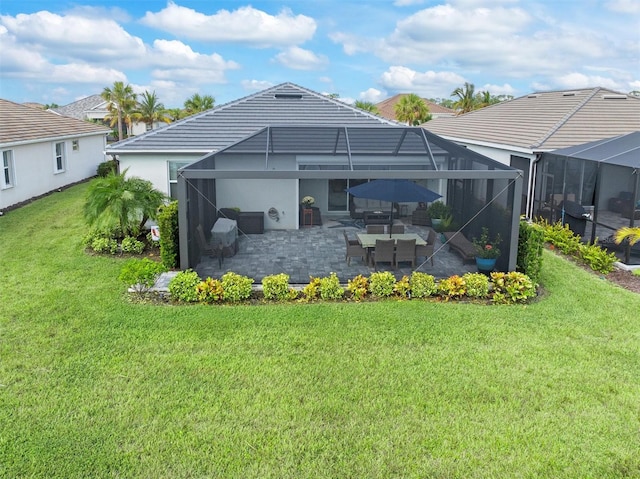 back of house with a yard, a patio area, and glass enclosure