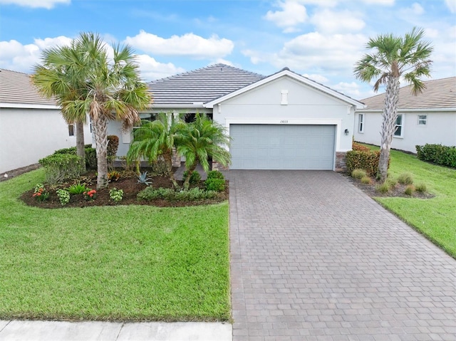 ranch-style home with a garage and a front lawn