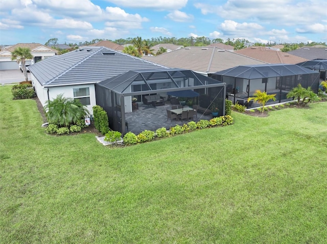 back of property featuring a patio, glass enclosure, and a yard