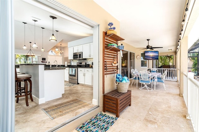 view of patio with ceiling fan, an outdoor kitchen, and a wet bar