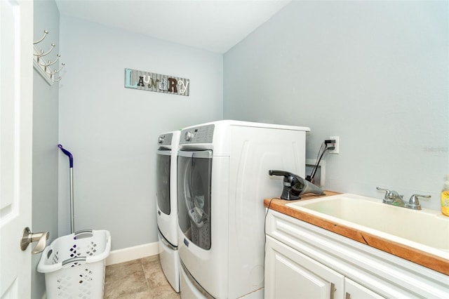 washroom with light tile patterned flooring, cabinets, sink, and washing machine and dryer