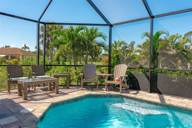 view of pool featuring glass enclosure and a patio area