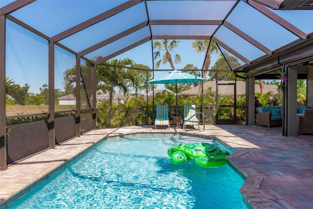 view of pool featuring outdoor lounge area, a patio, and glass enclosure