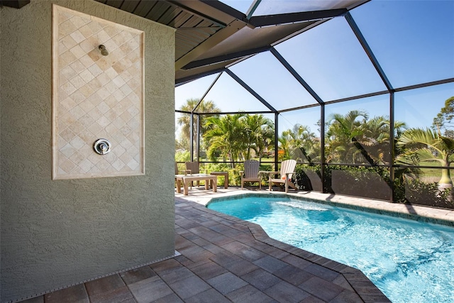 view of pool with a patio and a lanai