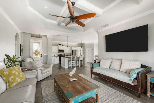 living room featuring ornamental molding, a tray ceiling, dark hardwood / wood-style flooring, and ceiling fan