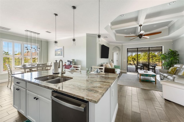 kitchen featuring a kitchen island with sink, stainless steel dishwasher, white cabinets, sink, and a healthy amount of sunlight