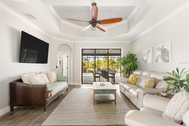 living room with ceiling fan, a raised ceiling, crown molding, and dark hardwood / wood-style flooring