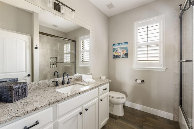 bathroom featuring vanity, a shower with shower door, toilet, and hardwood / wood-style flooring