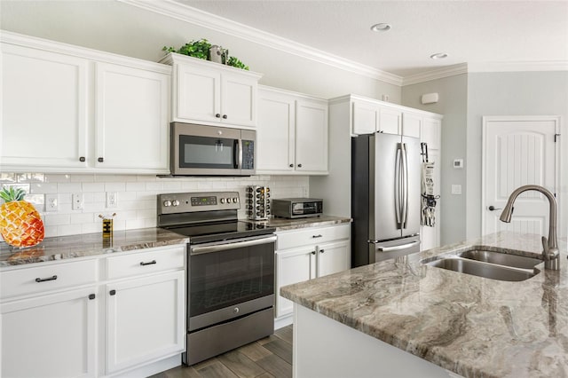 kitchen featuring light stone counters, appliances with stainless steel finishes, sink, and white cabinetry