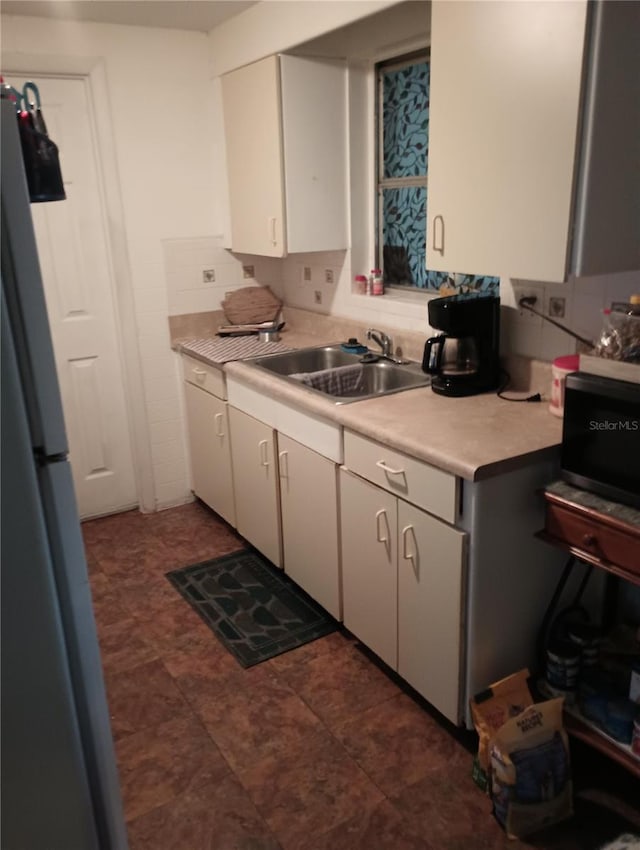 kitchen featuring tasteful backsplash, sink, and refrigerator