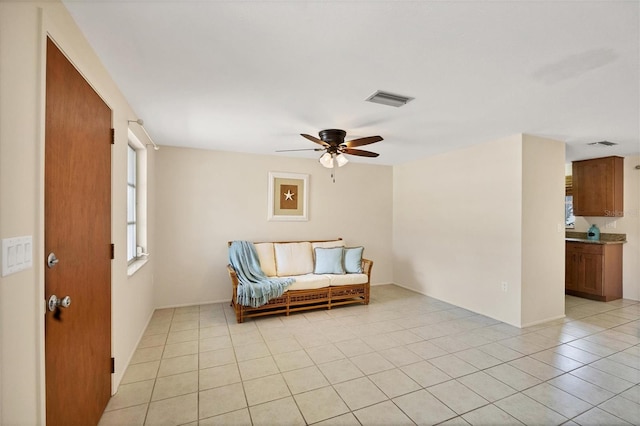 living area with light tile patterned flooring and ceiling fan