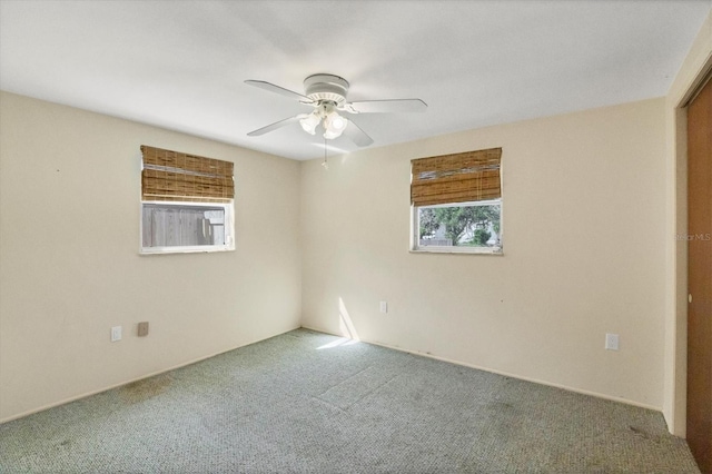 carpeted spare room featuring ceiling fan