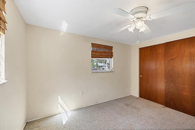 unfurnished bedroom featuring a closet, ceiling fan, and carpet flooring