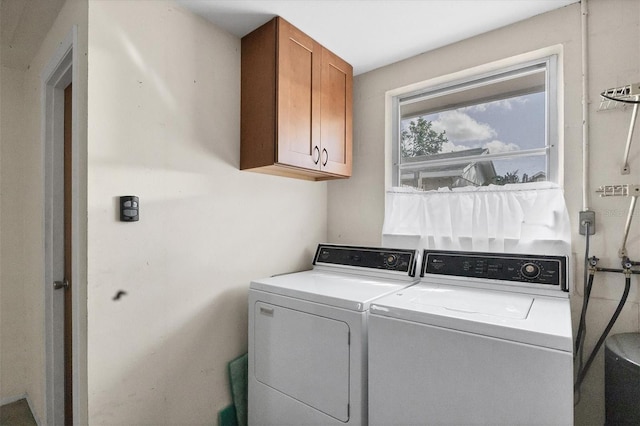 clothes washing area with washing machine and dryer and cabinets