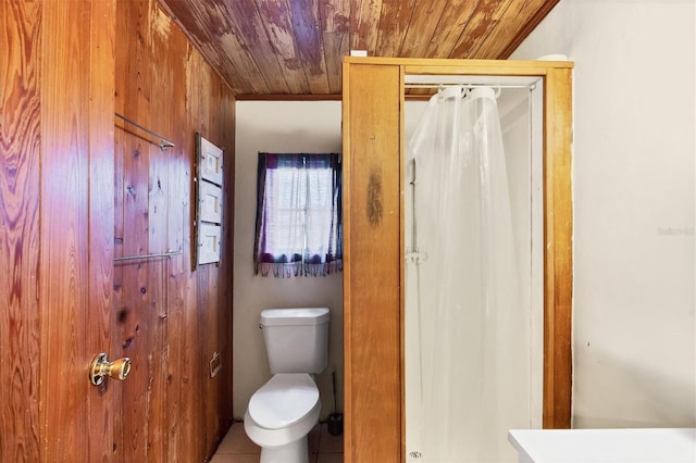 bathroom featuring toilet, wooden walls, wooden ceiling, and tile patterned flooring