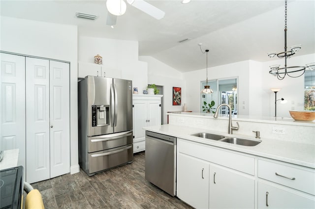 kitchen featuring sink, hanging light fixtures, white cabinetry, stainless steel appliances, and lofted ceiling