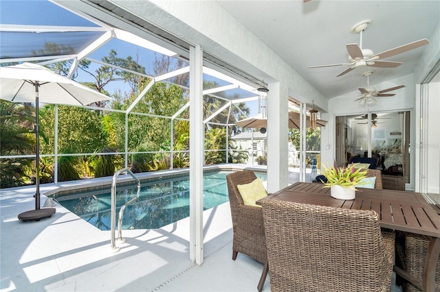 view of pool featuring a patio, glass enclosure, and ceiling fan