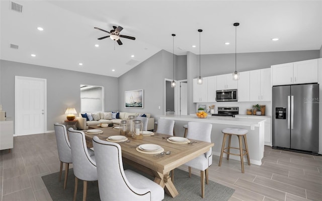 dining area with light hardwood / wood-style floors, high vaulted ceiling, and ceiling fan