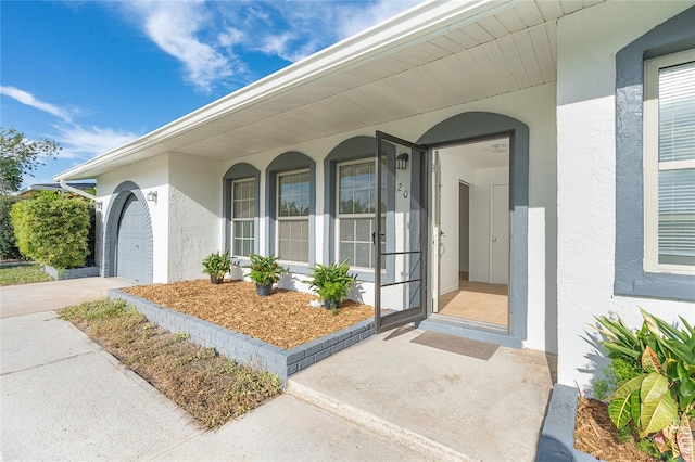 20 Annapolis Ln, Rotonda West, FL 33947 - property entrance featuring covered porch, an attached garage, and stucco siding