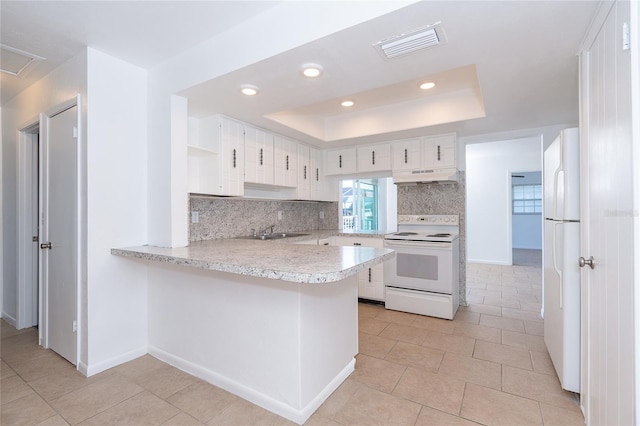 20 Annapolis Ln, Rotonda West, FL 33947 - kitchen featuring visible vents, light countertops, under cabinet range hood, a tray ceiling, and white appliances
