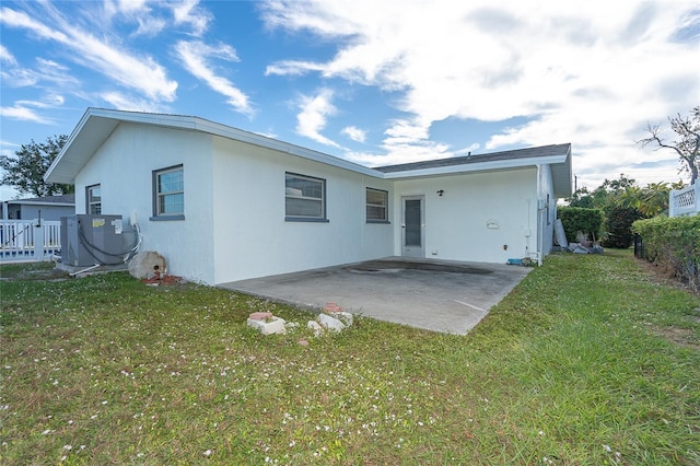 back of property featuring a patio area and a lawn