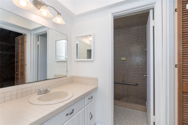 bathroom with vanity, tiled shower, and backsplash