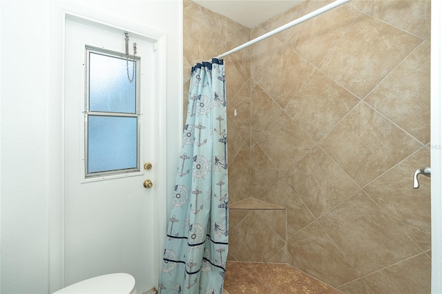 bathroom with a shower with curtain and toilet